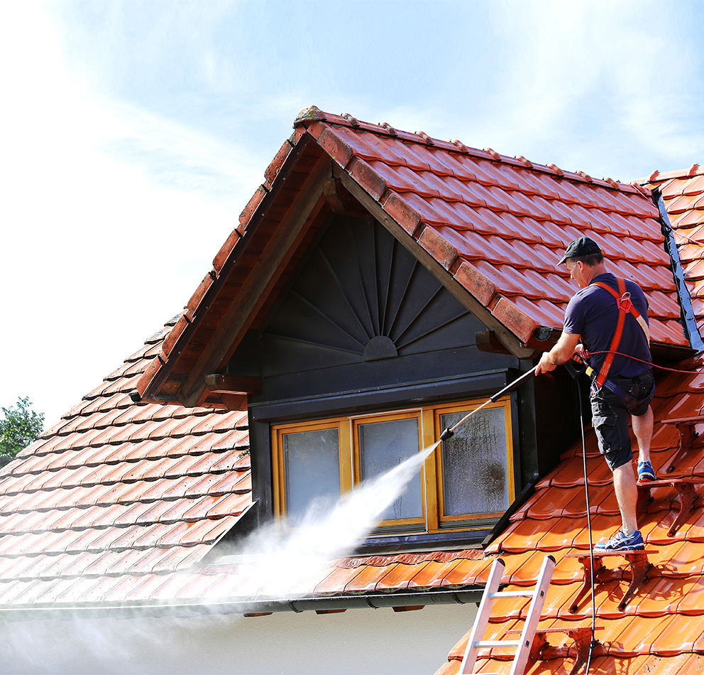 a man spraying a roof with a hose