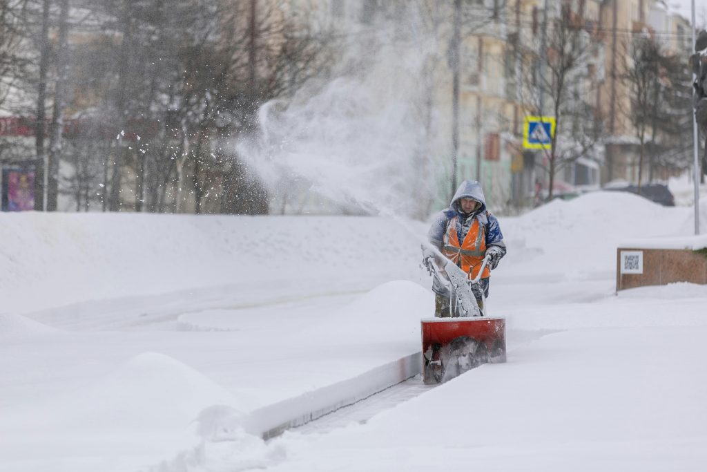 a person in a snow suit using a machine