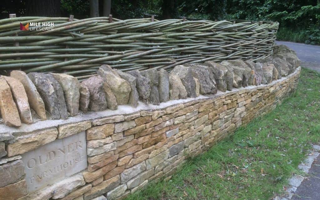 Privacy rock wall with fence topper