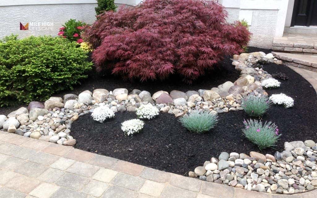 Low-maintenance front yard landscaping with rocks and mulch
